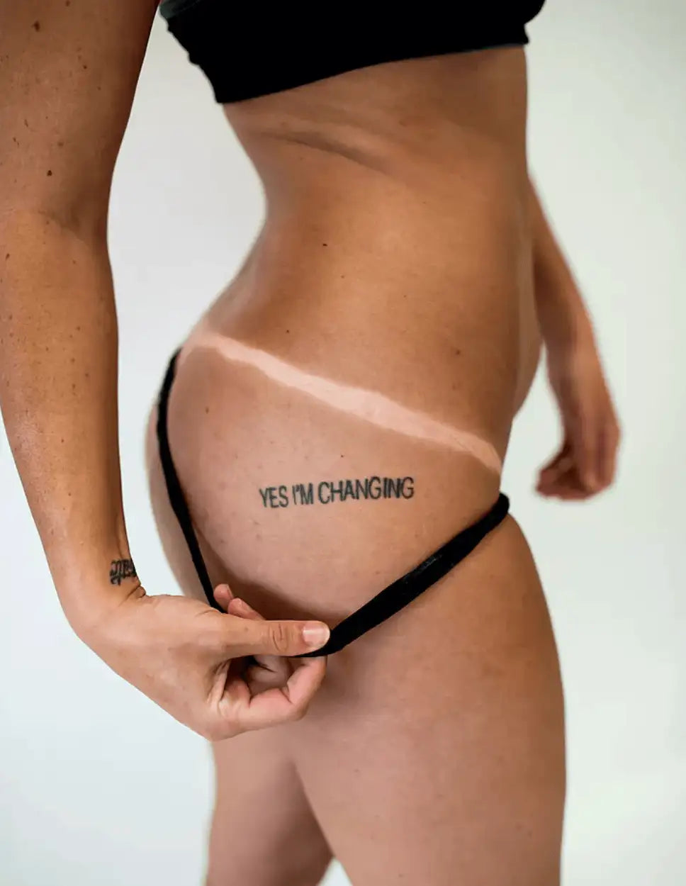Close-up of spray tan results showing a clear tan line on the hip and upper thigh